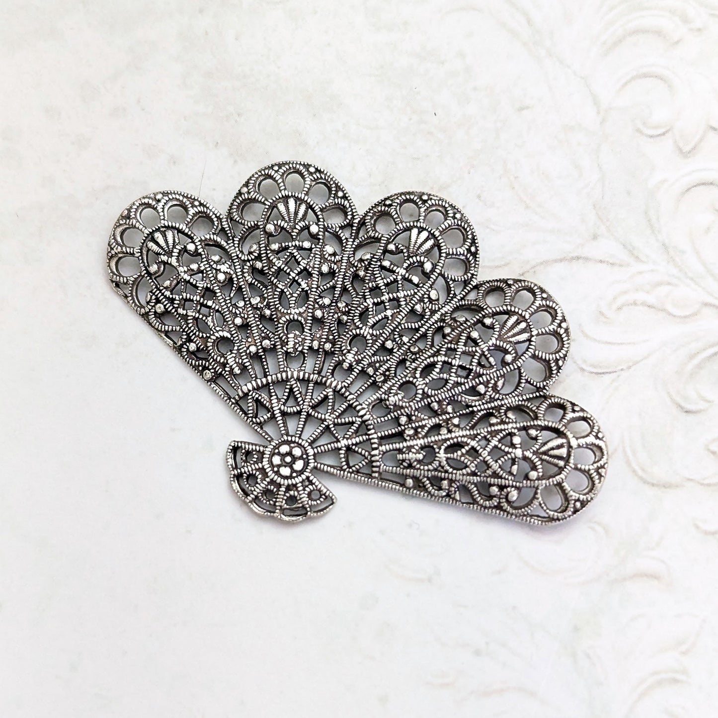 An antiqued silver-plated brass fan-shaped filigree for jewelry making or crafts