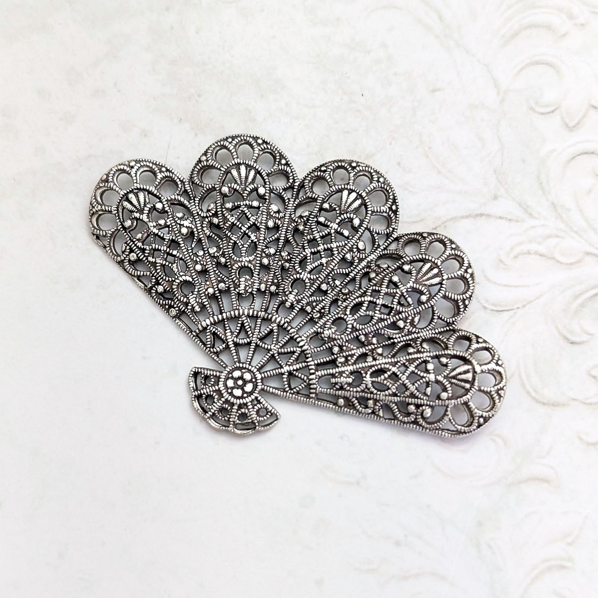 An antiqued silver-plated brass fan-shaped filigree for jewelry making or crafts